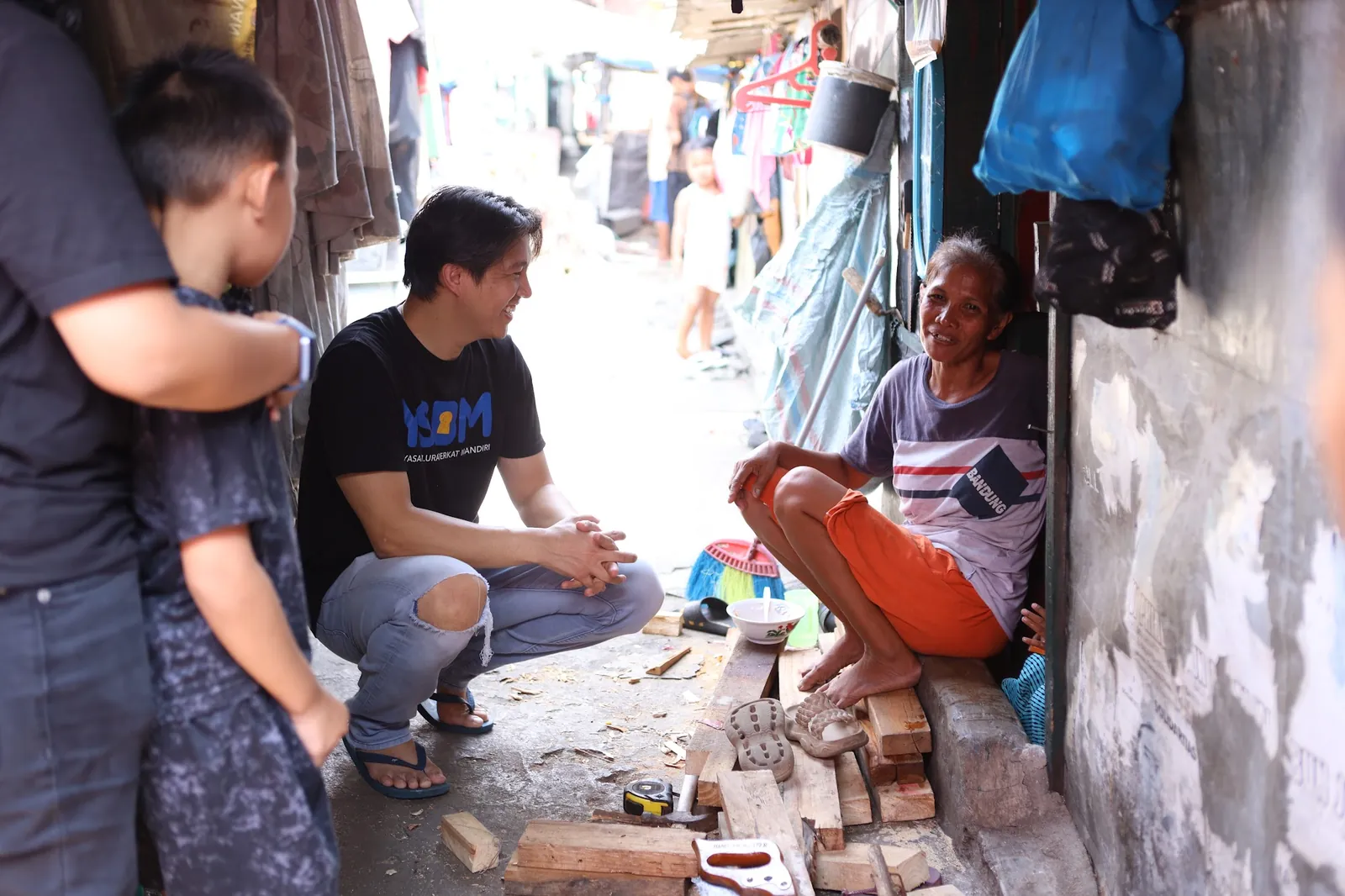 YSBM volunteers speak with a resident in a narrow Pekojan neighborhood