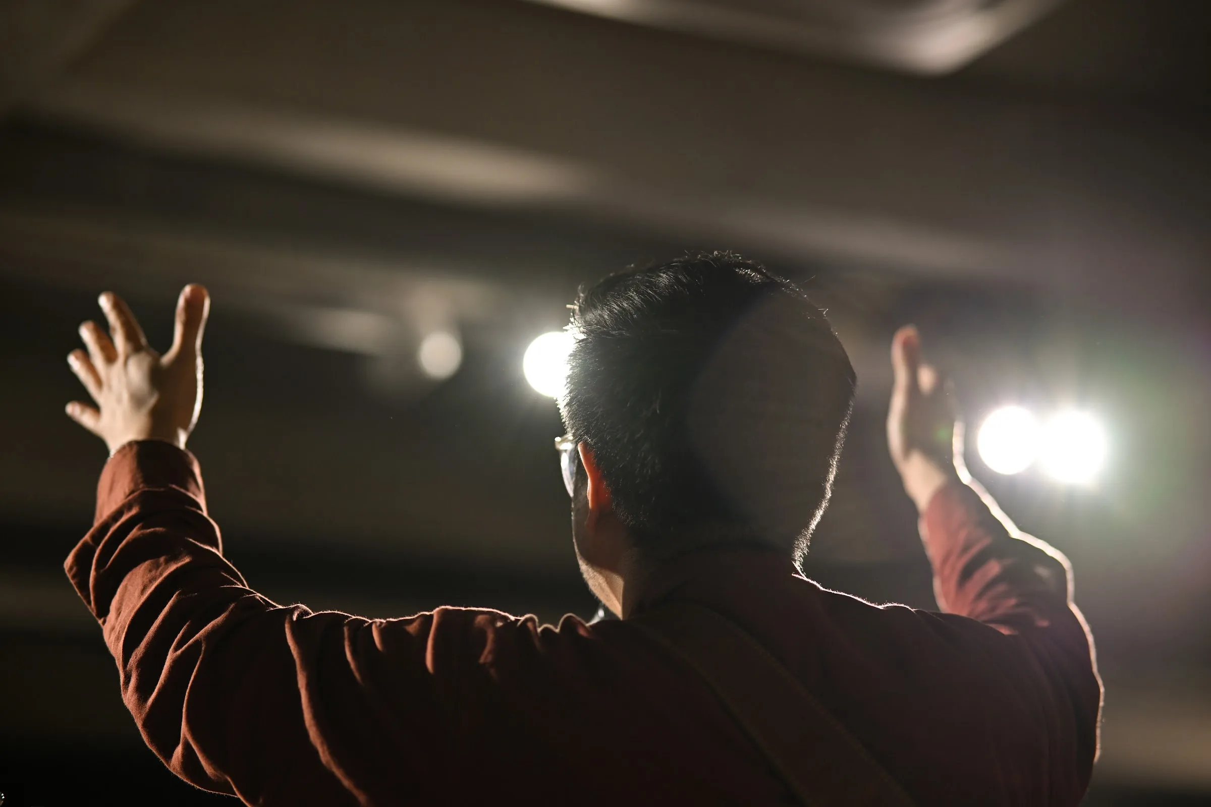 People raise their hands during a worship gathering