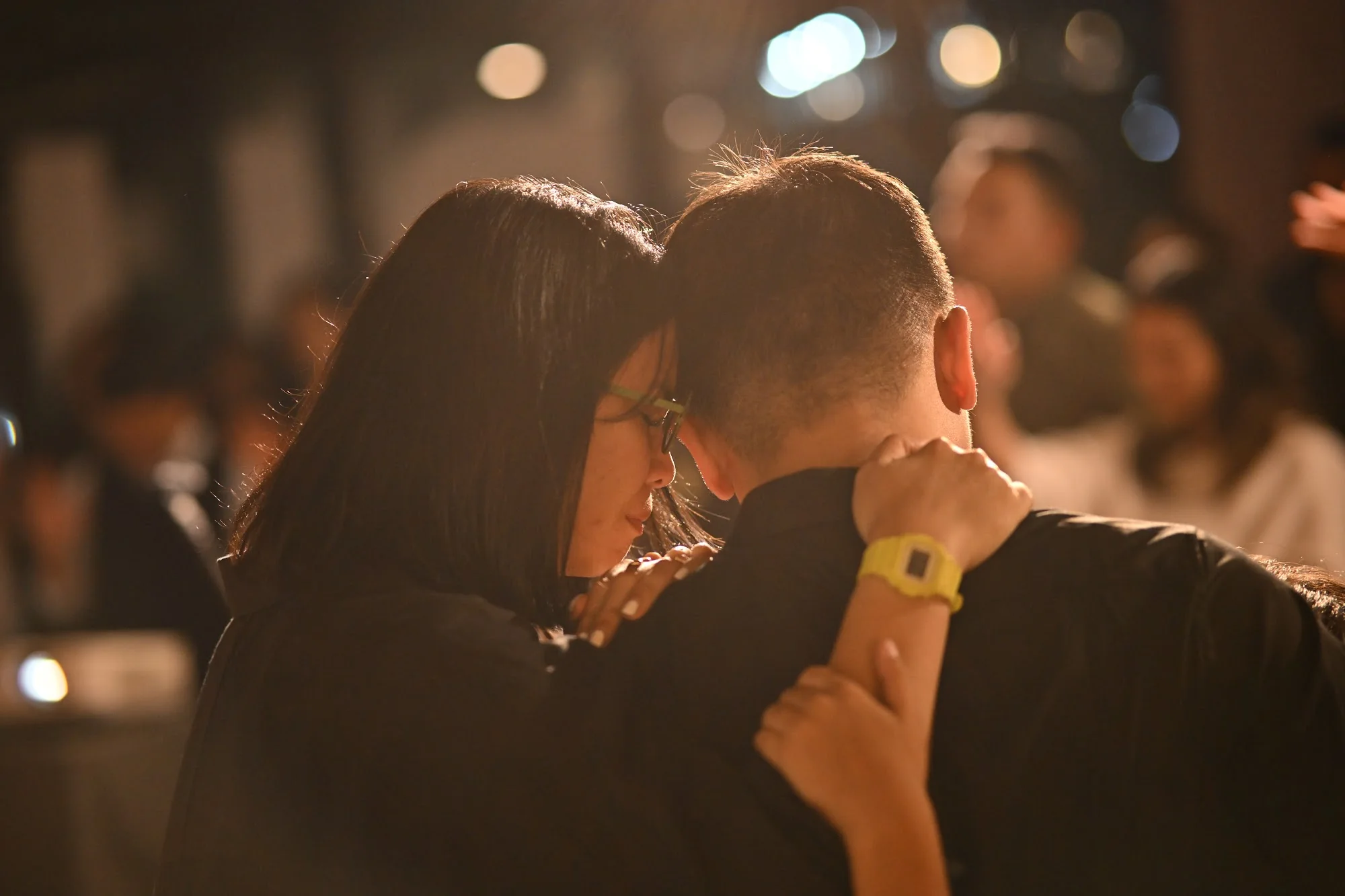 A woman prays with a man during City Soul Vol. 1 as the gathering continues behind them